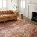 Loren Spice rug styled in a living room with a tan leather tufted sofa and white fireplace