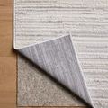 Townes rug corner lifted to reveal dual-layer backing on wood floor
