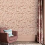 Room setting showing wallpaper paired with pink armchair, blue floral cushion, and matching pink curtains