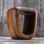 Loophole Wooden Accent Stool viewed from a low front corner angle emphasizing its open, hollow center.