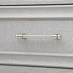Polished nickel drawer pull mounted on textured gray-washed grasscloth drawer front.