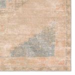 Close-up of the rug's bottom corner showcasing faded geometric corner motif and distressed finish