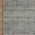 Corner close-up of Soho Jade Stone Rug on wood floor highlighting fringe and muted color tonal variation
