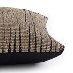 Side angle showing pillow thickness and contrast between woven front and black fabric back