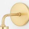 Close-up on gold round wall mount and arm extending to support the light fixture