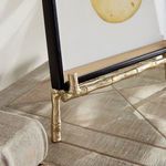 Close-up of front bottom corner showing gold textured bamboo detail supporting frame