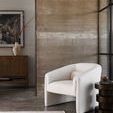 Side table positioned beside a white modern armchair against a textured concrete wall with minimal decor