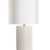 Matte white ceramic Pozzallo table lamp with cylindrical base featuring irregular vertical fluting and a white drum shade