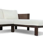 Low angle showing dark wood legs under white cushions at chaise and arm corner