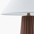 Close-up showing the seam detail on the white linen shade with part of ceramic base visible