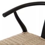 Close-up of curved black teak armrest and support meeting woven seat