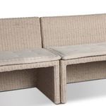 Close-up showing rattan weave meeting the tufted cream cushion on banquette