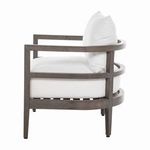 Side angle highlighting chair's curved frame and thick white cushions