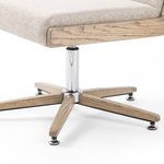 Close-up of chair’s wood and chrome swivel base with five extended legs and black floor protectors