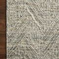 Close-up of the rug’s corner on dark wood floor, highlighting woven yarn detail and edging