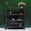 Hazel Serving Bowl displayed on bottom shelf of black rolling cart against green tiled wall