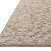 Side angle showing the rug's low-loop background and chunky higher-loop floral pattern texture