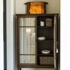Dining room scene with Finley Cabinet fitted alongside marble table, rattan chairs, overhead chandelier