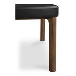 Close-up of chair leg and seat corner showcasing walnut wood grain and vegan leather grain texture