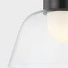 Close-up showing the glowing opal diffuser inside the clear glass shade and dark metal canopy