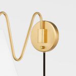 Partial gold Onda sconce arm with white shade and circular wall mount seen from left