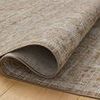 Curled edge of Ida Bark / Multi rug displaying soft pile texture and underside backing on wood floor
