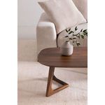 Close side angle of Godenza coffee table next to beige corduroy sofa with small textured vase and greenery