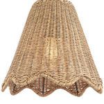 Close-up focus on scalloped bottom edge of woven rattan pendant shade with light glow