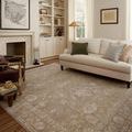 Louisa taupe and gold rug displayed in a bright living room with cream sofa and hardwood floors