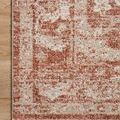 Top-down close detail of rug edge with part of design border on light wood floor