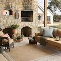 Beige side of rug shown in covered outdoor patio with stone fireplace and seating