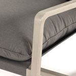 Close-up showing cushion stitching and weathered grey smooth wood armrest corner detail