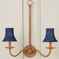 Two-arm natural wood wall sconce with Bell Indigo shades mounted on white paneled wall