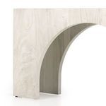 Console table in styled room with arched wood wall paneling, armchair, and ottoman