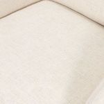 Top-down close view of the chair’s cushioned seat with cream fabric