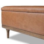 Detailed view of leather upholstery and oak frame near the leg on Iris Trunk