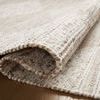 Partially folded Rivers Lilac / Ivory Rug showing weave texture and mixed natural fibers