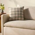 Walter Green pillow placed on off-white corduroy fabric sofa armrest with soft sunlight and floral decor nearby