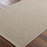 Runner style beige woven rug on wooden floor showing flat weave and precise edge stitching