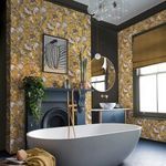 Bathroom setting showing Perrow Wallpaper on walls behind white freestanding bathtub and dark decor