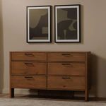 Pair of framed prints styled above wooden dresser in neutral room setting