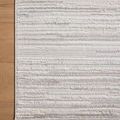 Flat lay close-up of Townes Rug corner on light wood floor highlights edge stitching and pattern detail