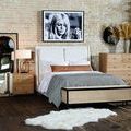 Nightstand side view in styled bedroom setting with lamp and books on top