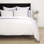Bedroom setting showing multiple Langston Bamboo Sateen shams styled with matching bedding and navy border detail