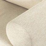 close-up of rounded armrest upholstery with fine woven texture in beige fabric