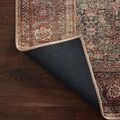Back corner of Wynter Onyx / Multi rug lifted to show black backing and beige edge stitching