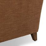 Close-up of brown fabric upholstery and side wood leg of Lynne Chair