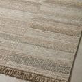 Angled close-up showing detailed woven pattern and tonal beige stripes with fringe