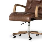 Close-up of chair seat and polished aluminum base with caster wheels and height lever.