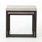 Front close-up of tables highlighting rectangular black metal frame structure and concrete edges